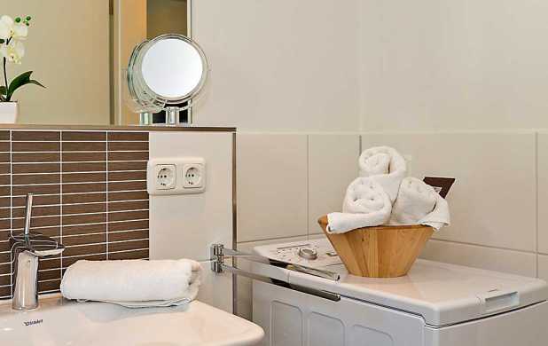 Sanitärbereich mit großem Spiegel, Kosmetikspiegel und Waschmaschine